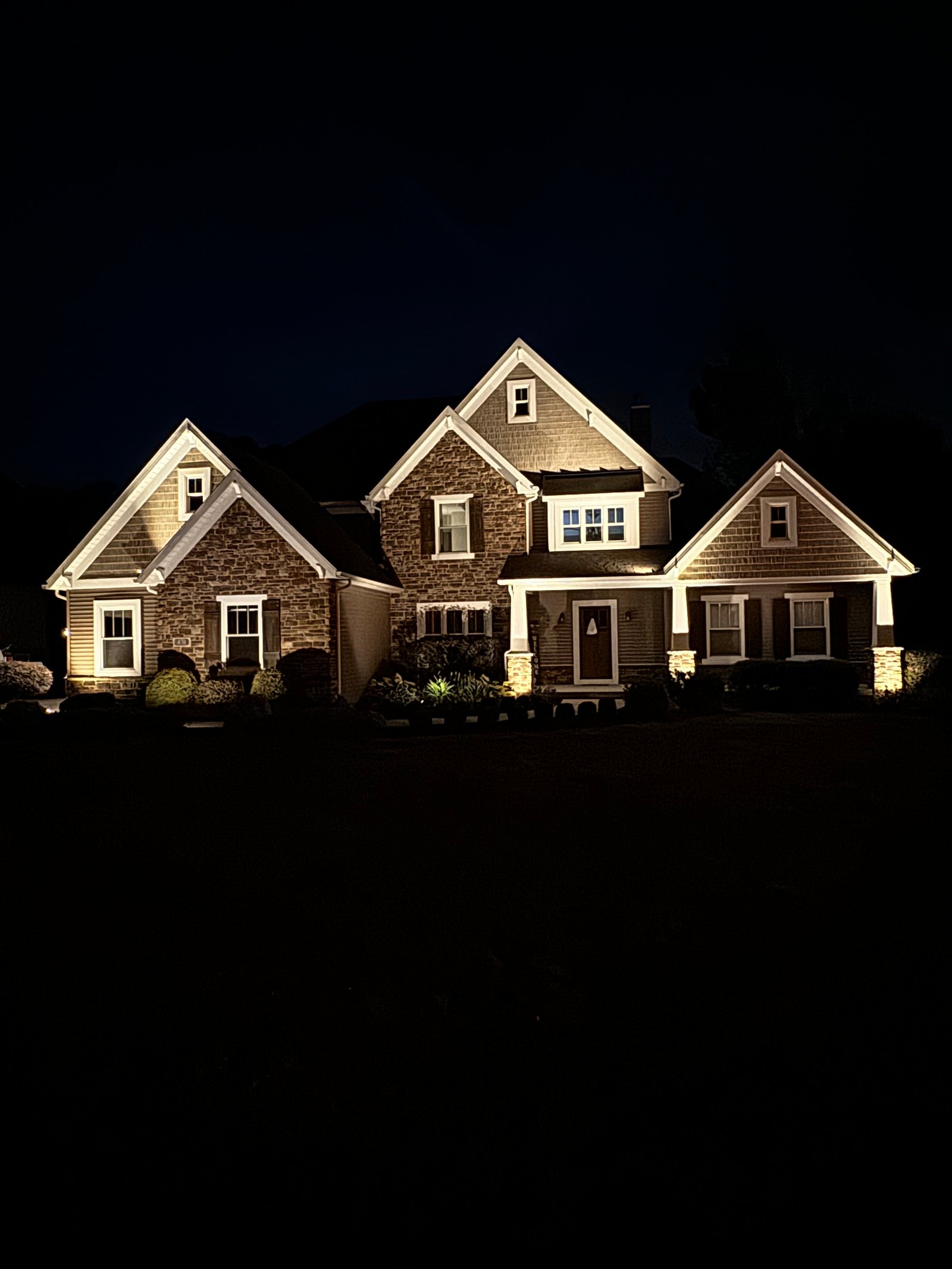 Home exterior at night with full architectural lighting installed